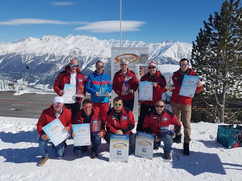 Auszeichnungen Aletsch Arena: Gruppe mit Urkunden und Pistengütesiegeln vor verschneiten Bergen.