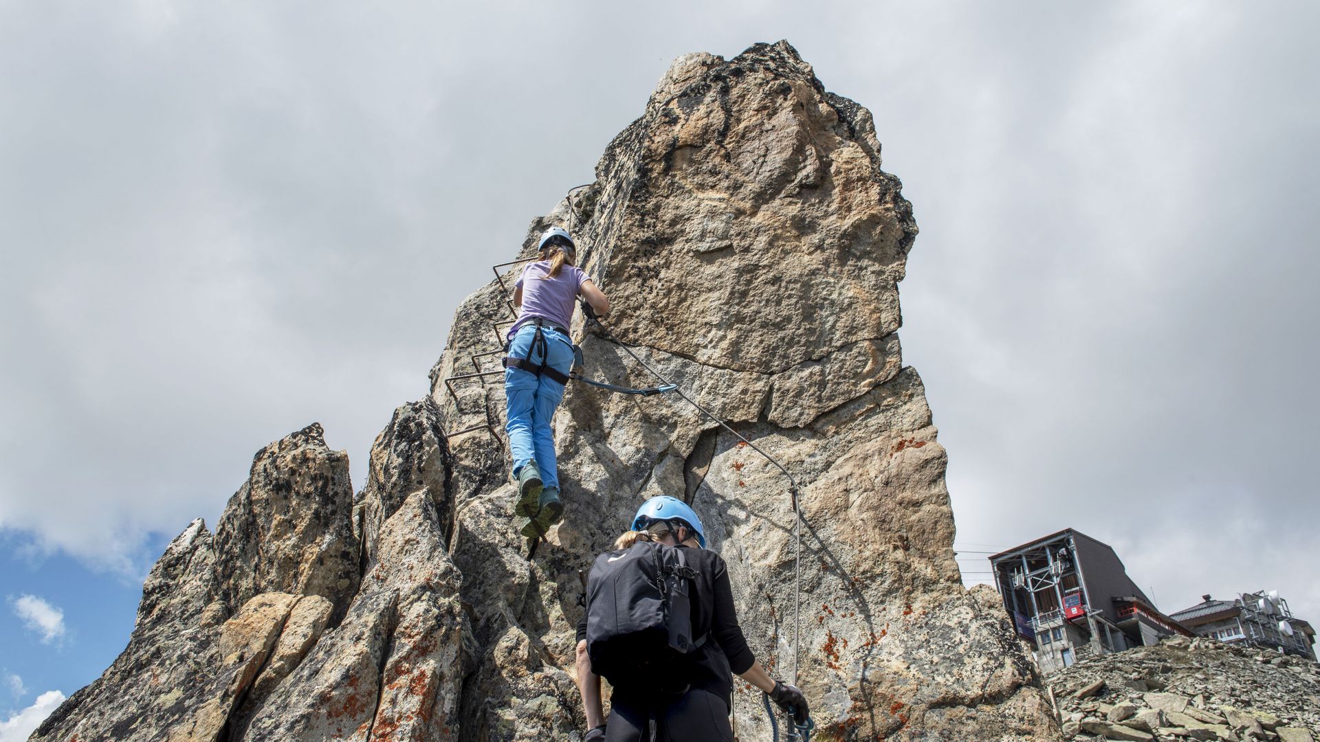 Assurés à une paroi rocheuse de l'Eggishorn, une femme et un enfant s'adonnent à l'escalade en milieu alpin dans l'Aletsch Arena.