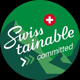 Grünes Swisstainable-committed-Logo mit Schweizer Kreuz auf der Seite Nachhaltigkeit Aletsch Arena.