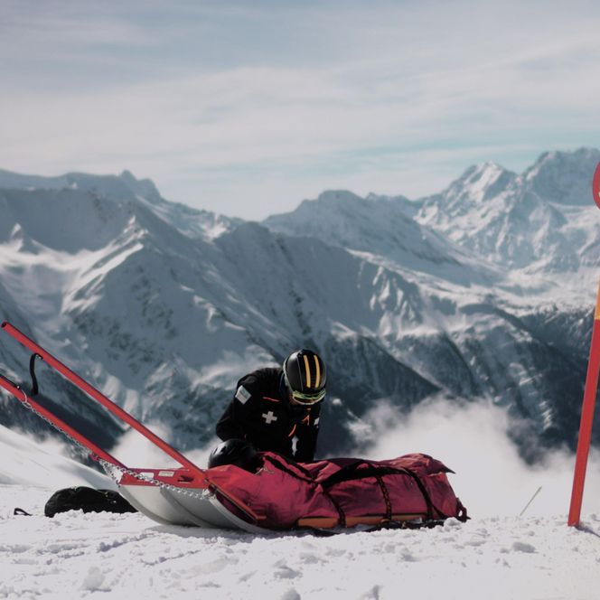 Jobs Aletsch Bahnen AG: Pistenrettung bereitet einen roten Rettungsschlitten neben der Pistenmarkierung 52 vor.