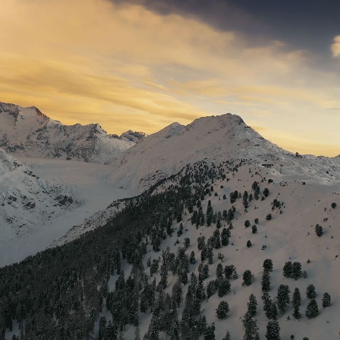 Un coucher de soleil à couper le souffle plonge les sommets enneigés de l'Aletsch Arena d'hiver dans une lumière dorée.
