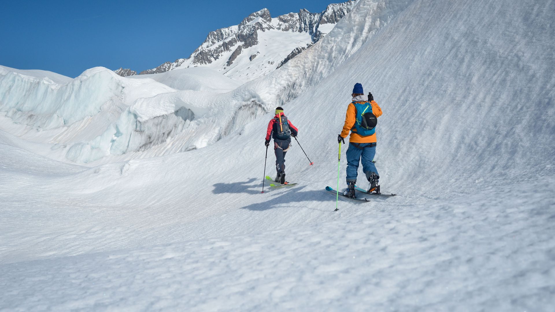 On a ski tour in the Aletsch Arena, two people are making their way between tall ice walls in the glacier region near Chatzulecher.