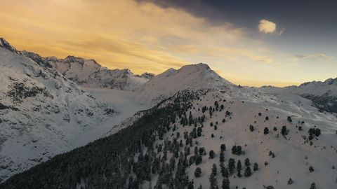 Verschneite Berggrate unter goldgelbem Himmel auf der Seite Auszeichnungen Aletsch Arena.