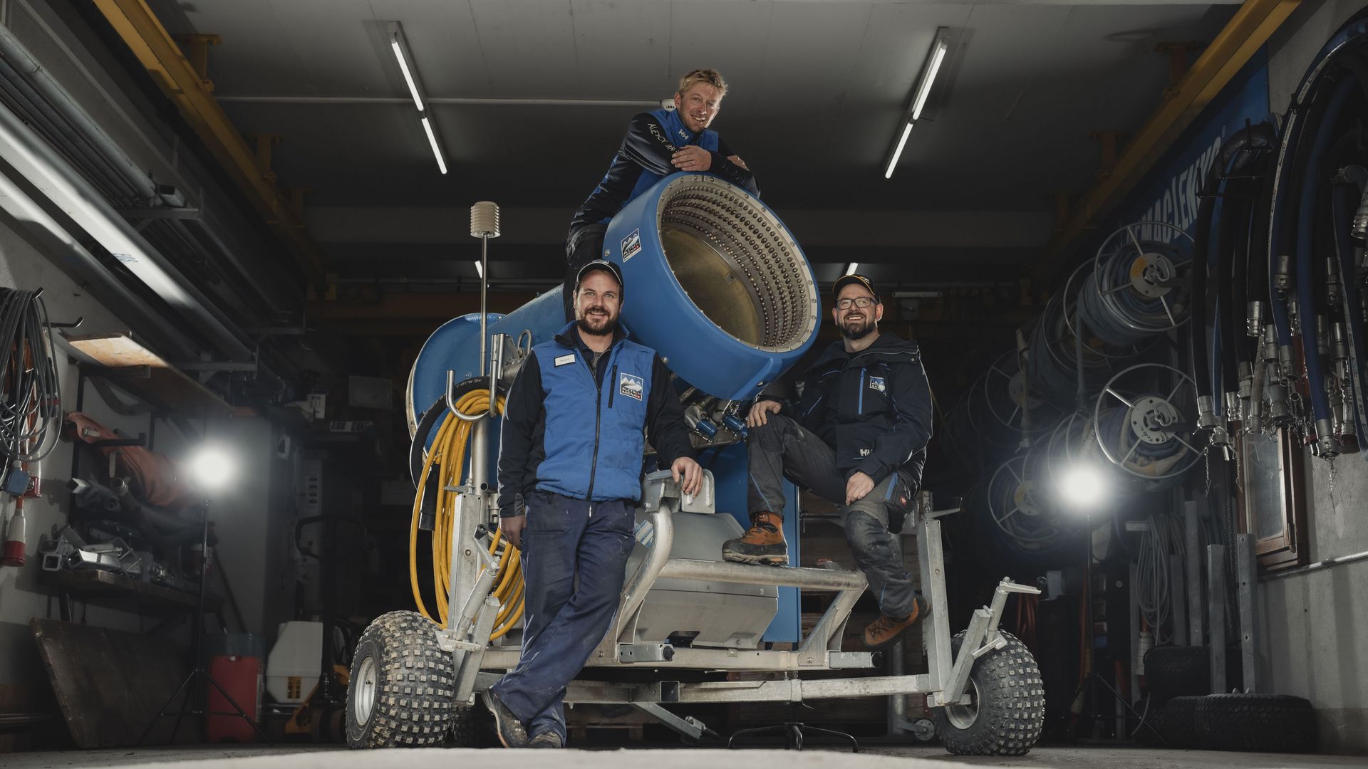 Jobs Aletsch Bahnen AG: Drei Personen aus dem Beschneiungsteam mit einer Schneekanone in der Halle.