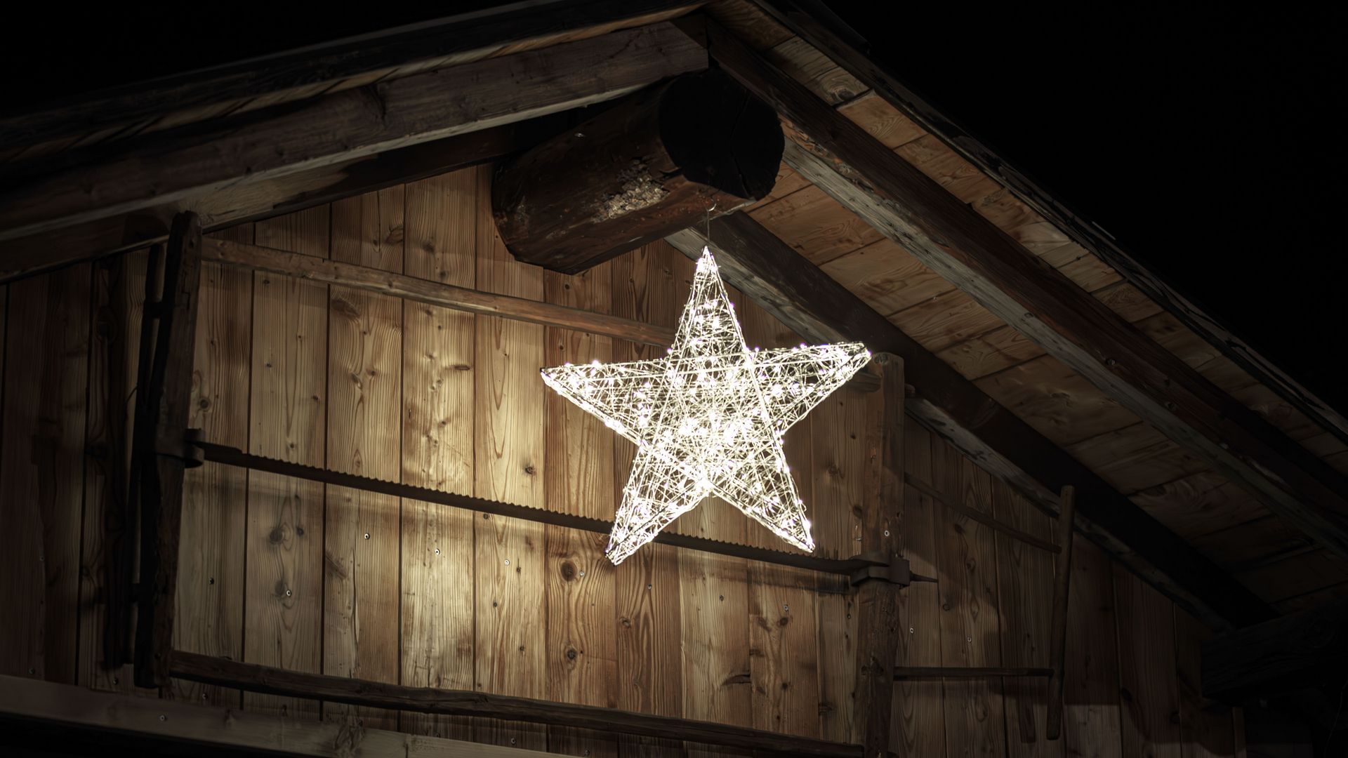 Weihnachten am Gommer Adventsmarkt mit leuchtendem Stern, der an einer Holzhütte befestigt ist und warmes Licht ausstrahlt.