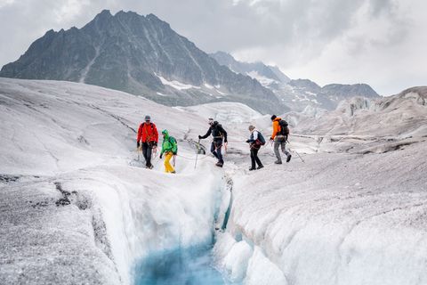 Eine fünfköpfige Gruppe wandert angeseilt über das Eis des Grossen Aletschgletschers beim Retreat Aletsch Arena.