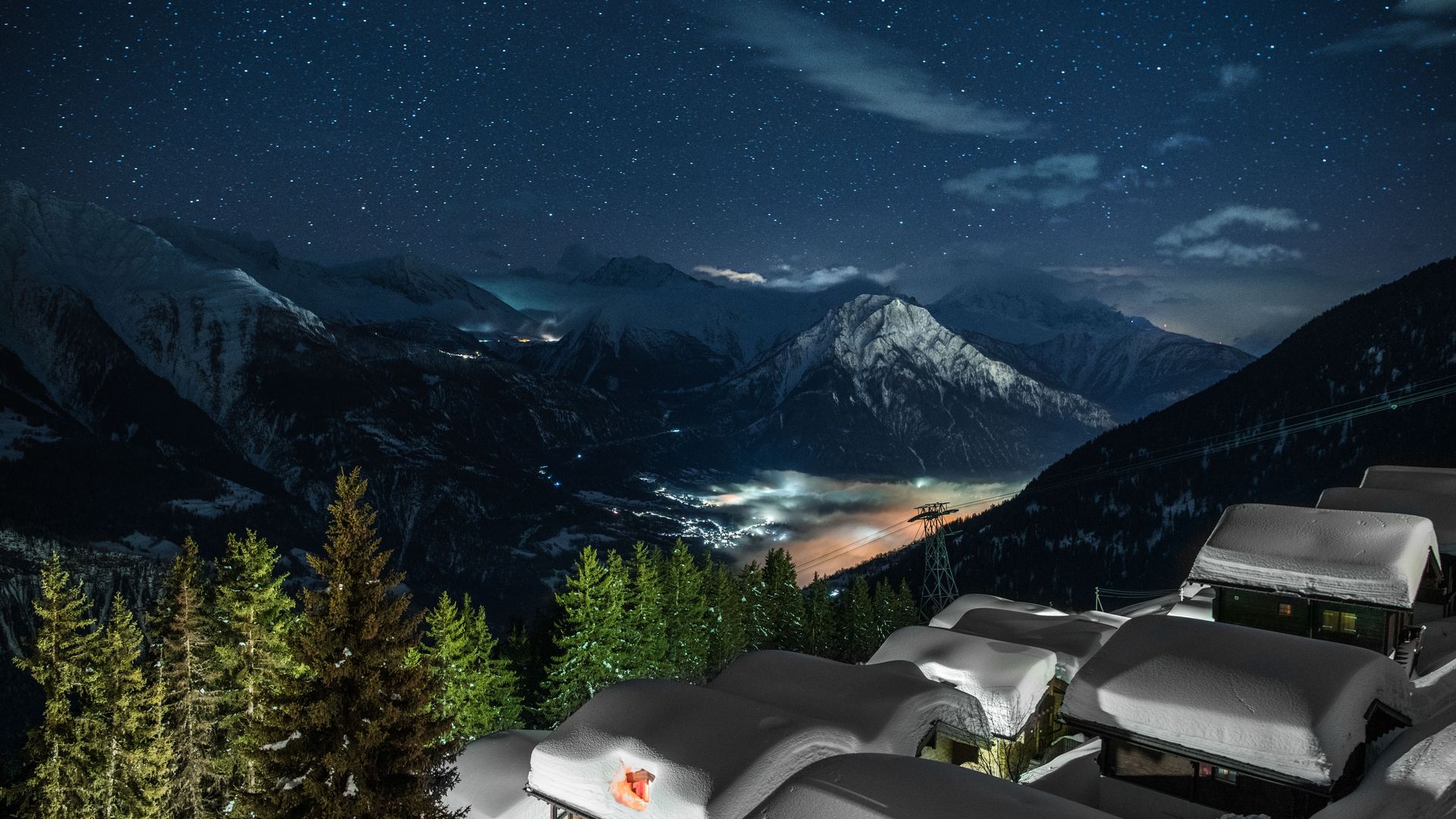 Vue sur le village enneigé de Riederalp Suisse de nuit, éclairé sous un ciel étoilé clair.