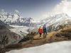 Couple sur un chemin de montagne, regardant l'impressionnant glacier d'Aletsch et les Alpes.