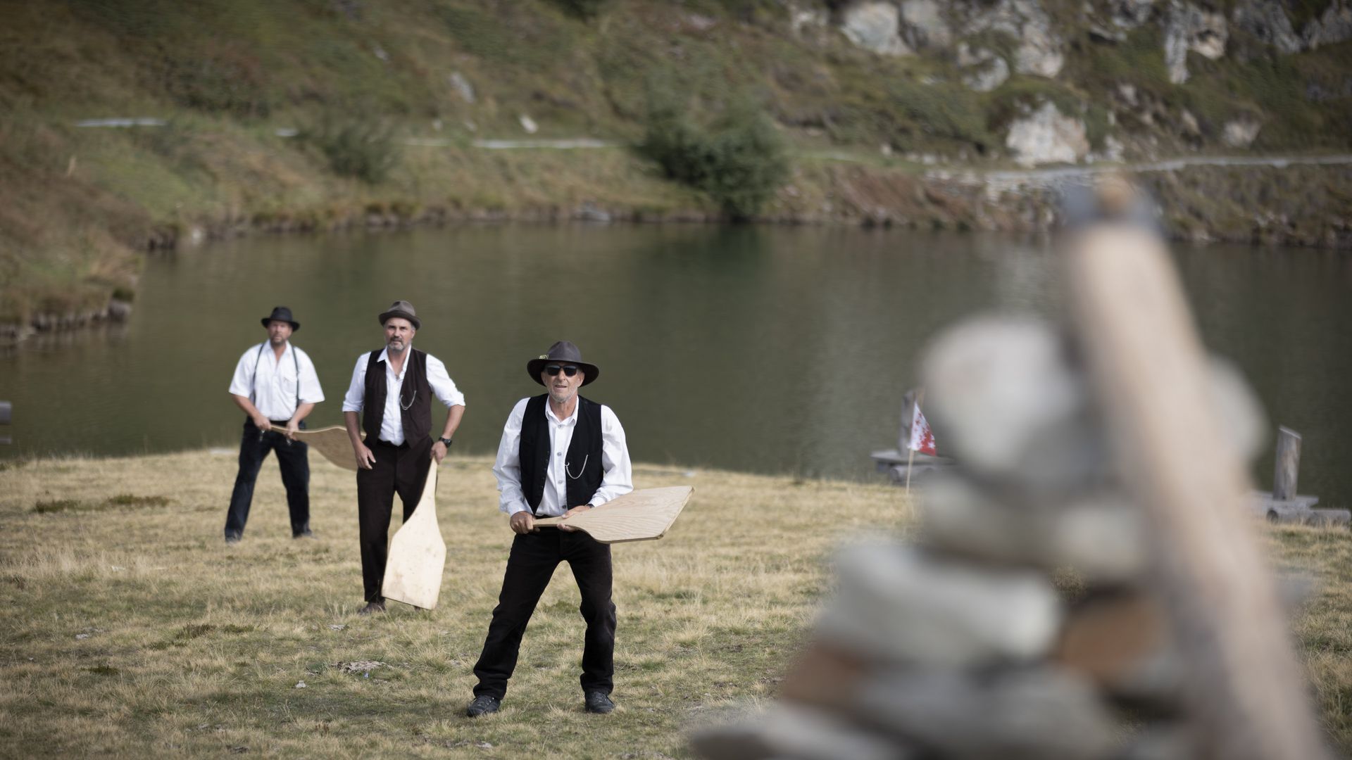 Des hommes portant des chapeaux jouent au jeu traditionnel de la balle à la main, le Gilihüsine, pour des traditions vécues dans l'Aletsch Arena.
