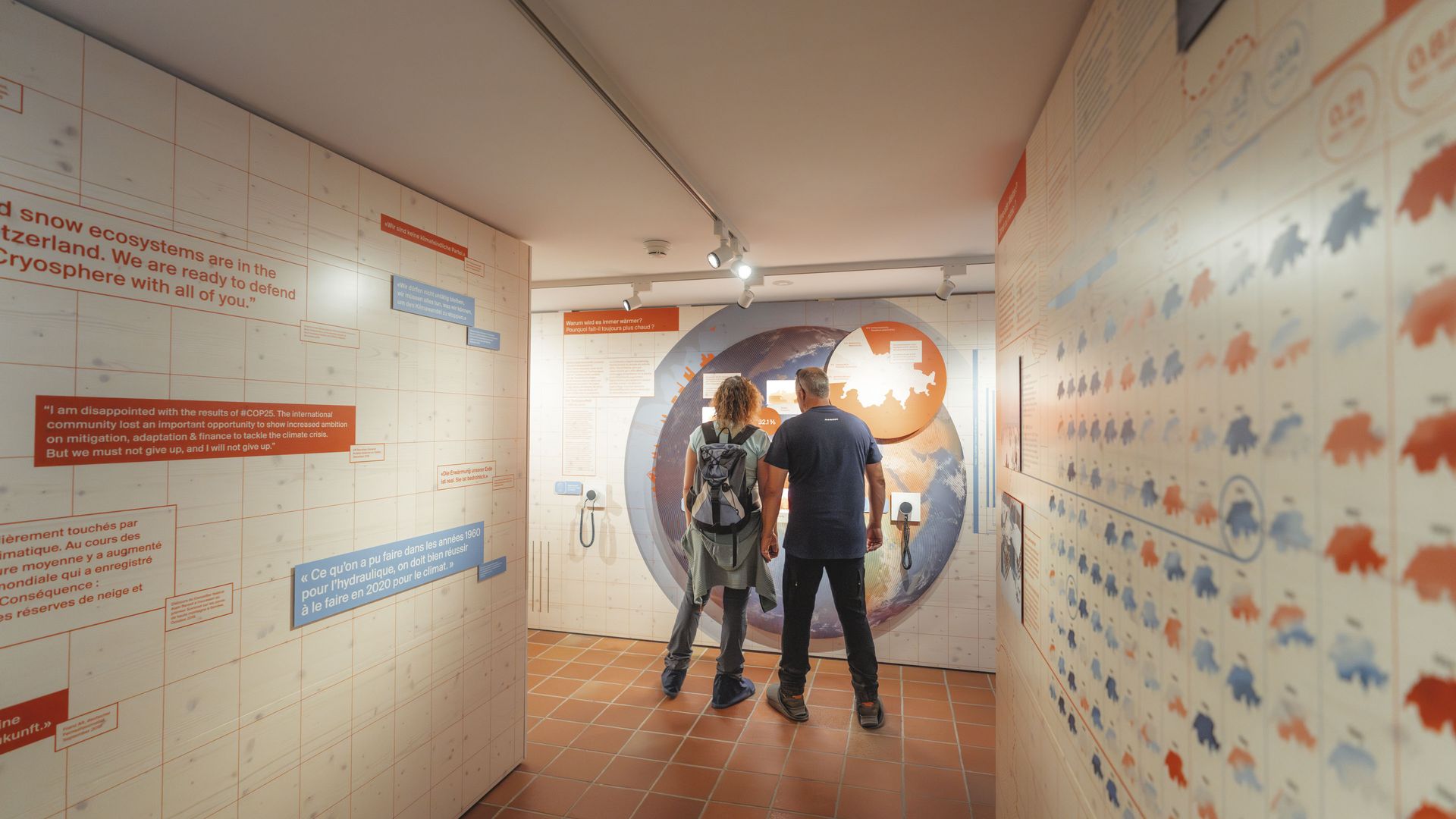 Zwei Besucher betrachten die interaktive Ausstellung im Pro Natura Zentrum Aletsch mit Informationen zum Gletscherschwund und Klima