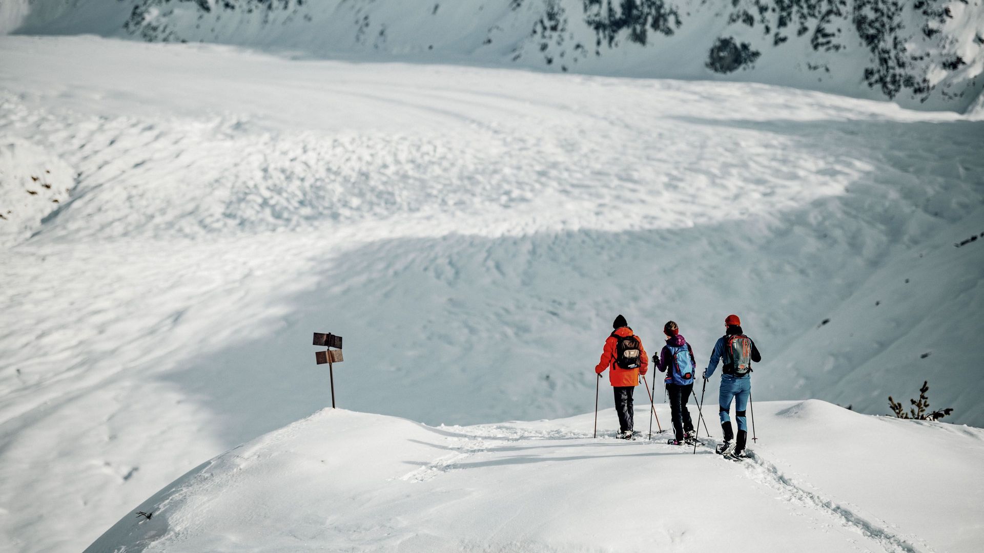 Drei Personen auf Schneeschuhtour Aletsch Grattour mit Blick auf den imposanten Grossen Aletschgletscher im Winter