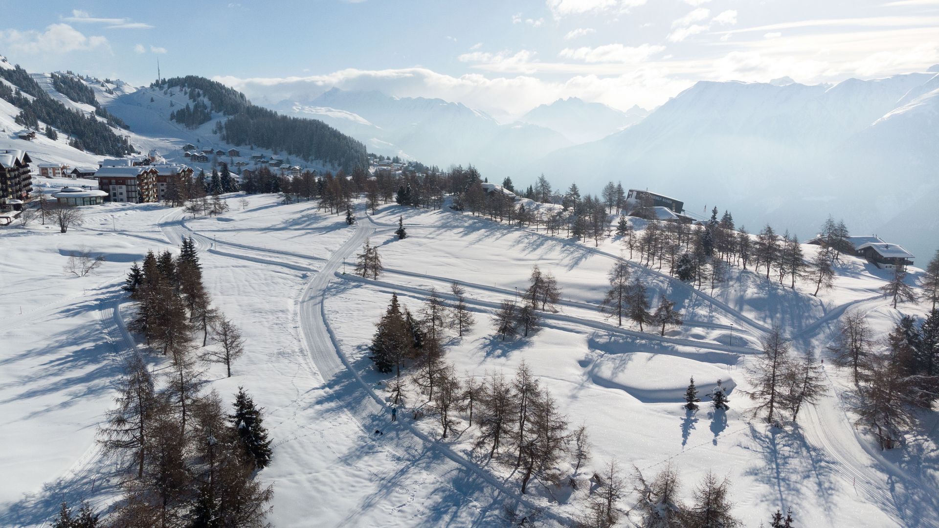 Cette image prise par drone montre la piste de ski de fond de l'Aletsch Arena à Riederalp, qui serpente à travers le paysage montagneux enneigé.