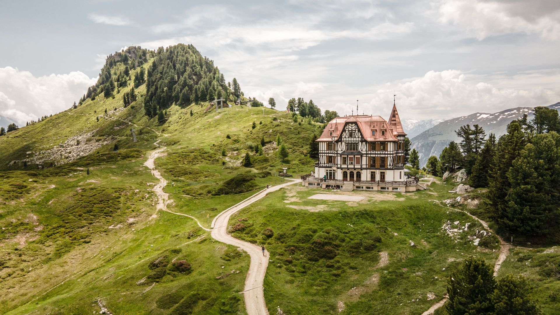 Vue aérienne de l'imposante Villa Cassel sur une crête verdoyante de Riederalp, en Suisse, un jour d'été.