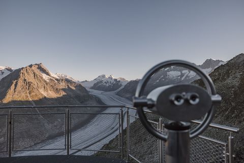 Ein Fernglas auf einer Aussichtsplattform mit Blick auf den Aletschgletscher bei einem Retreat Aletsch Arena.