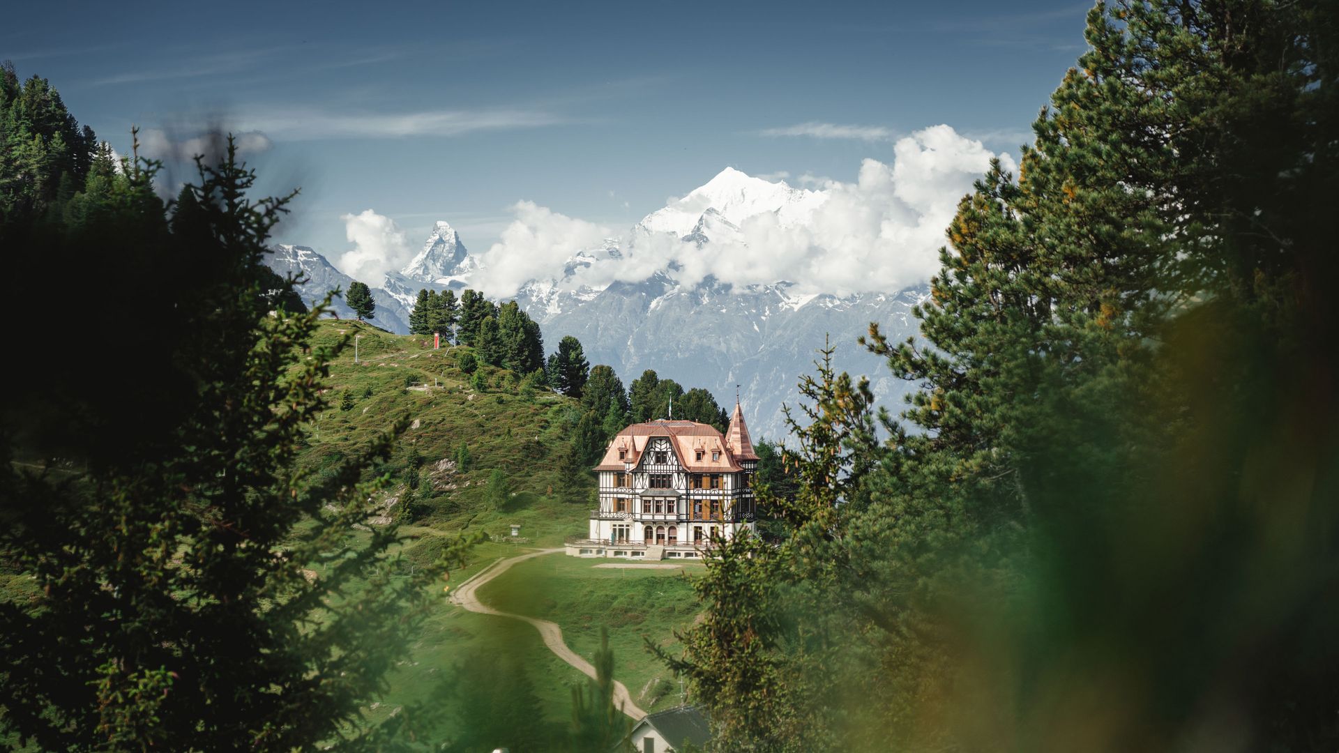 The striking Villa Cassel sits enthroned on a green mountain ridge, a popular destination when hiking in the Aletsch Arena.