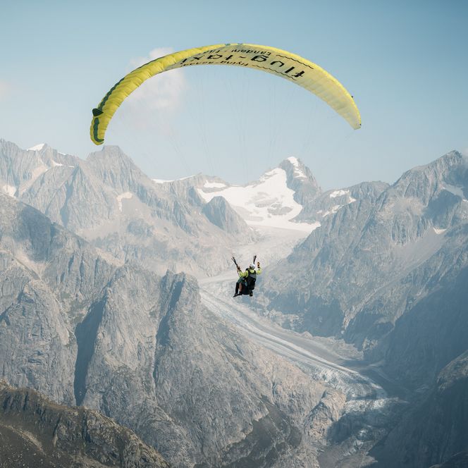 Gleitschirmflieger fliegen zu zweit über die Aletsch Arena