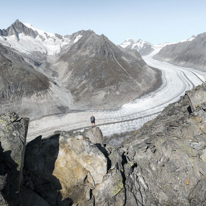Wanderer beim Stoneman Glaciara Hike auf felsigem Grat mit Blick auf den Grossen Aletschgletscher.
