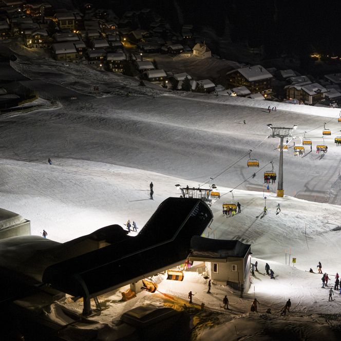 Une piste de ski éclairée avec un télésiège la nuit, une expérience formidable dans l'Aletsch Arena d'hiver.